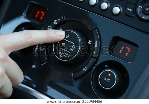 Hand ajusting\
the air conditioner in the\
car	\
