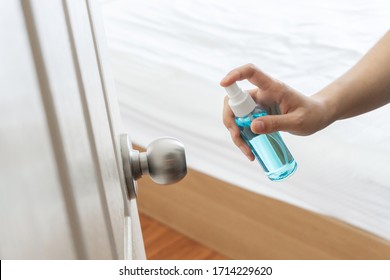 Hand Applying Alcohol Spray To Door, Doorknob Bedroom For Protect And Prevent Pandemic Disease, Covid-19, Coronavirus, Germs, Virus, And Cleaning At The House.