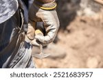 hand of an archaeologist holding a trowel in an archaeological excavation