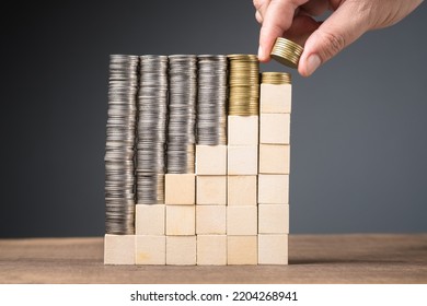 Hand Arrange The Heaps Of Coins Onto The Step Wood Cubes And Fill A Few Coins At The Last Step, Subsidy Money, Long Term Savings Concept