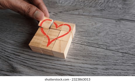 Hand arrange wooden cubes with red heart icon. Copy space for text. Love, valentine's day concept