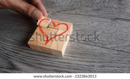 Hand arrange wooden cubes with red heart icon. Copy space for text. Love, valentine's day concept