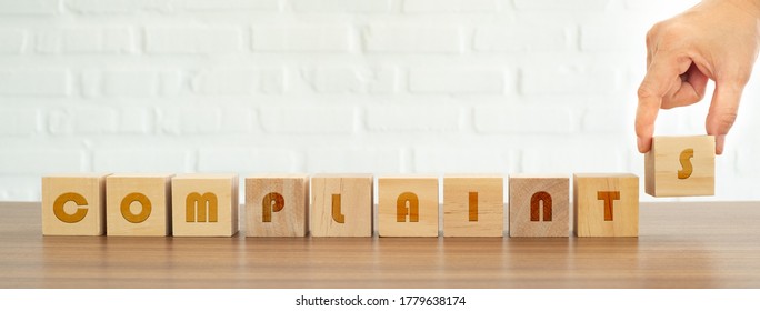 Hand arranges wooden blocks as "complaints" messages. The concept of listening to the opinions of customers in order to improve efficiency. - Shutterstock ID 1779638174