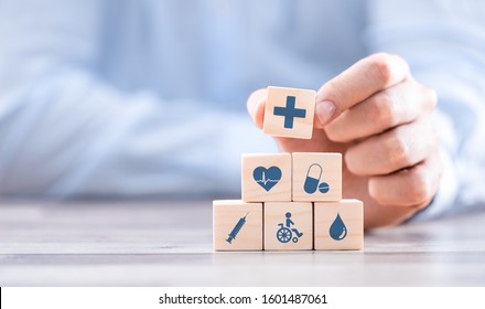 Hand arranging wood block with healthcare medical icon. Health insurance - concept.