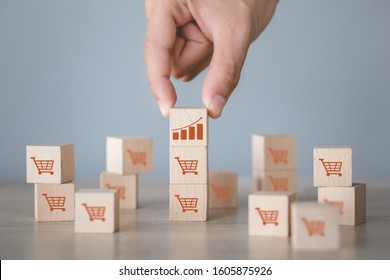 Hand arranging wood block stacking with icon Graph and shopping cart symbol upward direction, - Shutterstock ID 1605875926