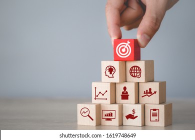 Hand arranging wood block stacking with icon arrow and business,targeting the business concept. - Powered by Shutterstock