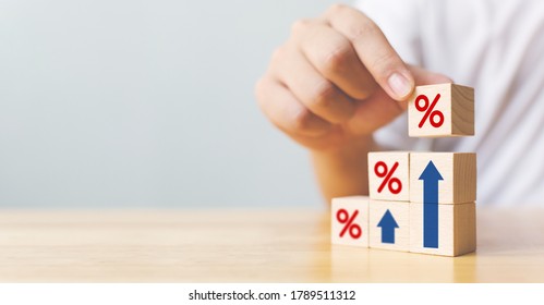 Hand arranging wood block stacking as step stair with sign percent and arrow up symbol. Interest rate financial and mortgage rates concept - Powered by Shutterstock