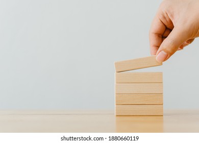 Hand Arranging Wood Block Stacking On Top With Wooden Table. Business Concept For Growth Success Process