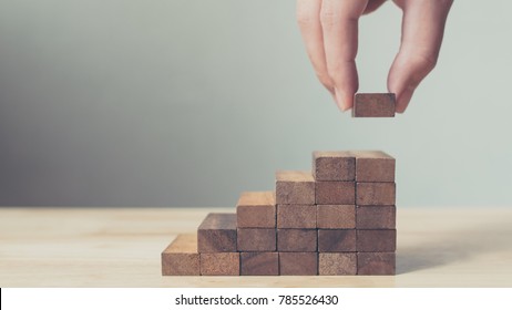 Hand arranging wood block stacking as step stair. Ladder career path concept for business growth success process, Copy space - Shutterstock ID 785526430