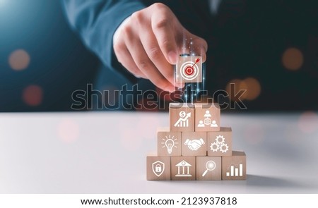 Hand arranging wood block stacking with business strategy and Action plan,targeting the business concept.business development concept.