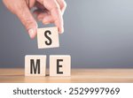 Hand arranging wooden blocks with the letters 