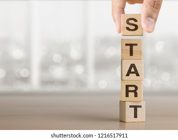 Hand arranging wooden blocks with the word START. Start, Start up, new career or new business, mindset concept.