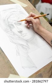 The Hand Of The Artist With A Pencil, Drawing A Portrait.