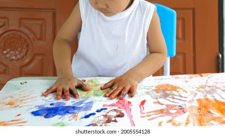 Hand Of Asian Child Boy Painting On Paper At Home. Kid Playing Watercolor With Happy Moment. Concept Of Art, Family Fun Activity, Creative Learning.