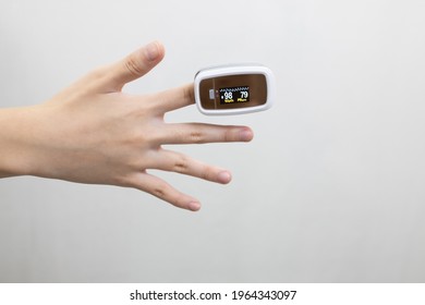 Hand Of Asian Child Girl With An Attached Pulse Oximeter On Fingertip,lady Measuring Heart Rate,checking Oxygen Saturation Level In The Blood,diagnosis Of Coronavirus Or COVID-19 At Home,health Care