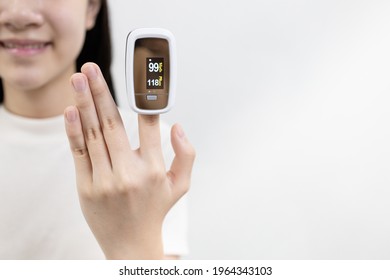 Hand Of Asian Child Girl With An Attached Pulse Oximeter On Fingertip,lady Measuring Heart Rate,checking Oxygen Saturation Level In The Blood,diagnosis Of Coronavirus Or COVID-19 At Home,health Care