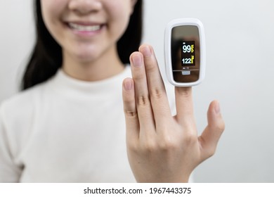 Hand Of Asian Child Girl With An Attached Pulse Oximeter On Fingertip,people Measuring Heart Rate,pulse Rate,checking Oxygen Saturation Level In The Blood,diagnosis Of Coronavirus Or COVID-19 At Home