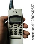 the hand of an Asian man holding an old cellphone,isolated on white background