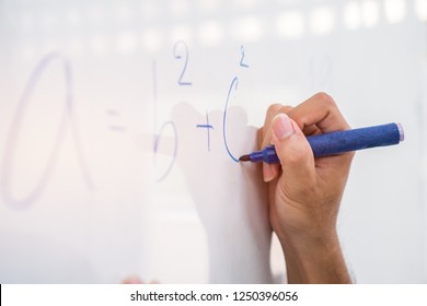 Hand Asian solving solution Math formulas, doing mathermatics problem on whiteboard in classroom at high school. Back to School concept