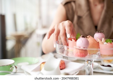 hand of asian woman picking a dessert from glass plate