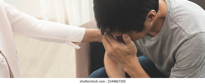 Hand Of Asian Young Man, Male Suffer From Mental Health Need To Therapy With Psychologist Sitting On Couch To Consult, Psychiatrist Giving Encouragement To Patient By Touching To Make His Feel Relaxed