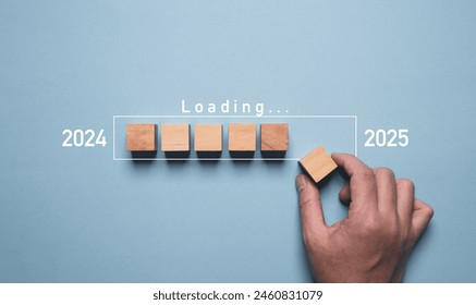 Hand assemble wooden block cube to update technology downloading tool bar status from 2024 to 2025 , Merry Christmas and happy new year concept. - Powered by Shutterstock