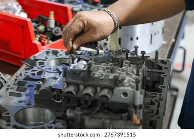 ​Mechanic hand assembling a complex hydraulic transmission control valve body component during a professional gearbox overhaul and repair service.