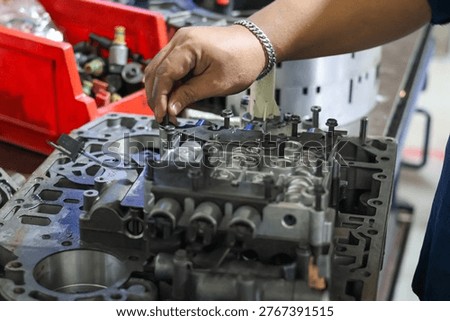 ​Mechanic hand assembling a complex hydraulic transmission control valve body component during a professional gearbox overhaul and repair service.