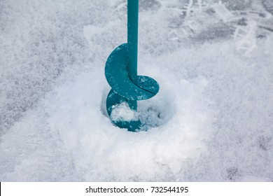 A Hand Auger Drills And A Hole In The Ice