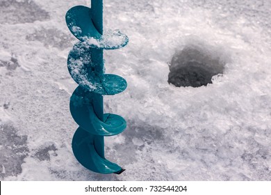 A Hand Auger Drills And A Hole In The Ice