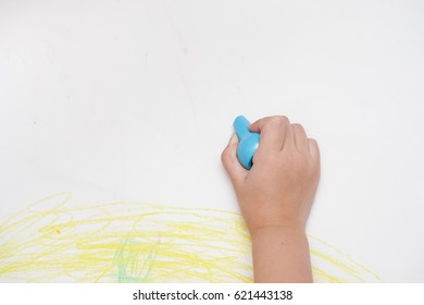 A hand of baby drawing lines and shapes with colorful crayons. The crayons can put in the fingers to draw easily. - Powered by Shutterstock