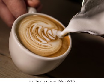 hand of barista making latte or cappuccino coffee pouring milk making latte art 
 - Powered by Shutterstock