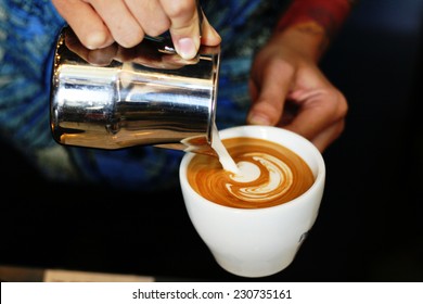 hand of barista making latte or cappuccino coffee pouring milk making latte art  - Powered by Shutterstock