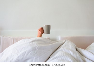 hand in bed with coffee