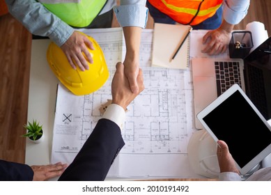 Hand in hand between project contractors and customers due to negotiation of expenses and investments, construction and repair of residential buildings. - Shutterstock ID 2010191492