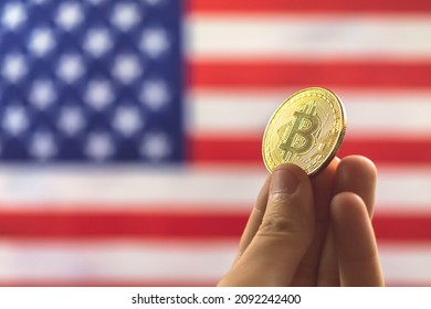Hand with bitcoin and USA flag on background. Cryptocurrency and United States of America concept 