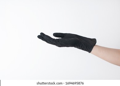 hand black gloves of doctor or hair stylist on white background. gloves are worn on the arm. - Shutterstock ID 1694695876