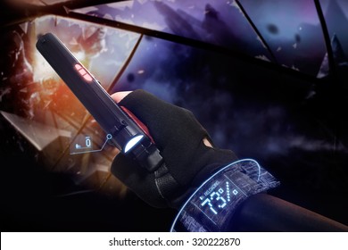 Hand in black gloves holding a recharging handgun. First person view hand in black leather gloves holding a futuristic fantasy neon recharging handgun with neon red, blue indicators and panels.