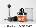 Hand blender kit with fresh vegetables on white background