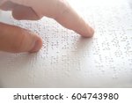 Hand of a blind person reading some braille text touching the relief. Empty copy space for Editor