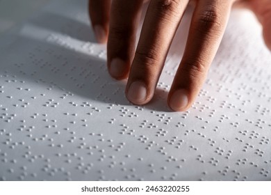 Hand of a blind person reading some braille text on page paper to learn. Finger of blind student touching the braille alphabet Code on sheet. - Powered by Shutterstock