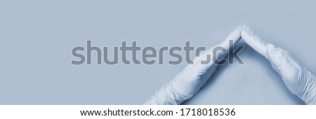 Hand in blue glove defend everything. Safety insurance and warranty concept. antibacterial surface cleaning. Anti virus hygiene procedure in business. Grey background . Top view