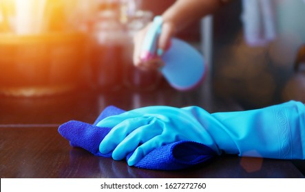 hand in blue rubber glove holding blue microfiber cleaning cloth and spray bottle with sterilizing solution make clean and disinfection for good hygiene
