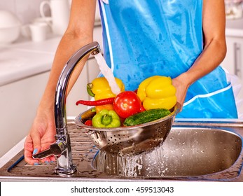 Hand body part woman washing fruit at kitchen. Pouring water on woman hands and vegetable.