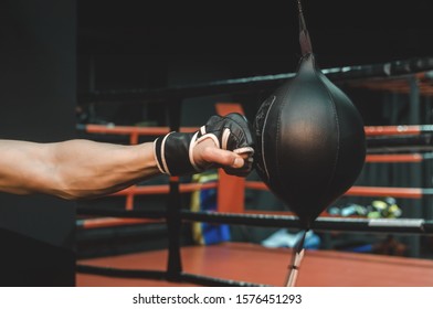 Hand In Boxing Gloves Beats Punching Bag Close Up.