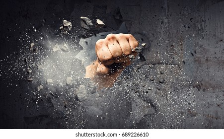 Hand breaking through the wall. Mixed media - Shutterstock ID 689226610