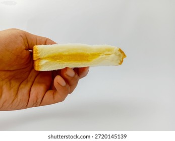 Hand bringing slice of bread with pineapple jam isolated on white background.