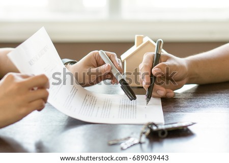 Hand of broker showing to client where to sign signature contract.