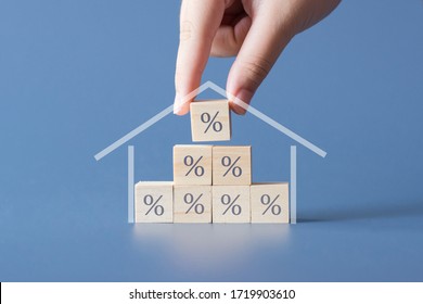 Hand building a house by wooden cubics with the percentage sign on them.Concept of Interest rate financial  mortgage rates,home loans,home refinance. - Shutterstock ID 1719903610