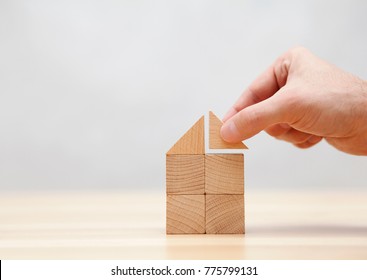 Hand building house with wooden blocks 